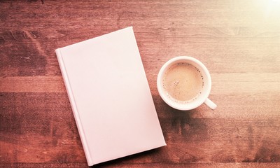 Cup of hot coffee with notebook on wooden table background, top view