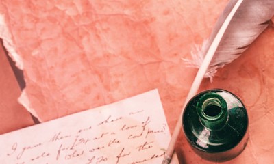 White feather quill pen, glass inkwell and old letter