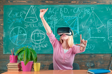 Augmented reality. Woman in VR glasses. Confident woman in virtual reality headset pointing in air. Modern education. Back to school. Virtual education. Virtual reality gadget. Virtual cyber space