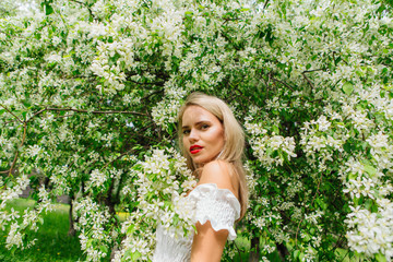 Sexy modern bride enjoing blooming apple tree flowers.