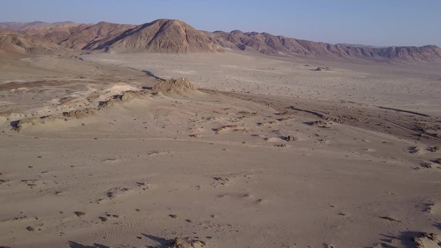 Las Tortolas beach aerial footage at Atacama Desert the sunset ray lights illuminate this amazing and idyllic beach in the desert, an arid awe landscape full of sand dunes, an idyllic destination