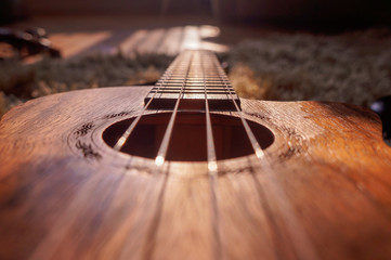 Fototapeta premium Down the strings. from the neck of a guitar looking down to the base of the instrument. Long exposure throughout the image with a dark background and a strike of light on the midsection