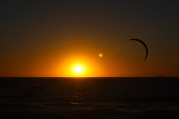Kite surfing at sunset on Scarborough beach in Perth Western Australia. Clean sunset in the distance and the surfer about 50 meters away.