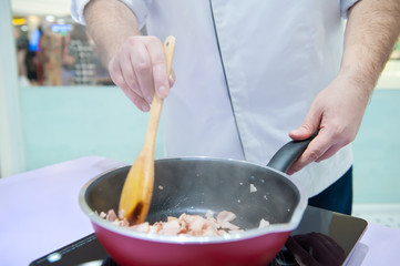 Close-up view, chef stand cooking bacon in the pan
