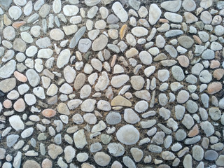 Gravel floor texture background. Floor background with stones. Rocks on the path for health. Round stone floor background.