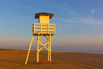 A lifeguard cabin on a sandy beach at sunrise. Mediterranean Sea beach in Valencia region of Spain.