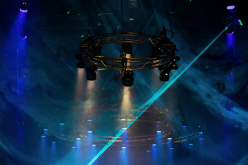 Performance moving LED Par lighting on construction light beam ray downward in blue color with Laser smoke graphic, on Concert and Fashion Show stage ramp, low light exposure with grain and noise