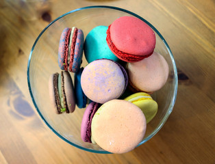 tasty macaroon cake of different colors on wooden background
