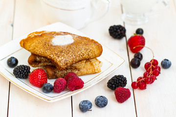 Healthy breakfast, homemade classic russian pancakes with fresh berry and sour cream, white wooden background. Sweet Homemade Stack of Pancakes with Butter, fresh forest berries and cream with tea.