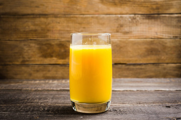 Fresh squeezed orange juice on the rustic background. Selective focus. Shallow depth of field. 