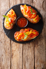 Spicy cajun fillet chicken baked with cheese and bell pepper close-up on a board. Vertical top view