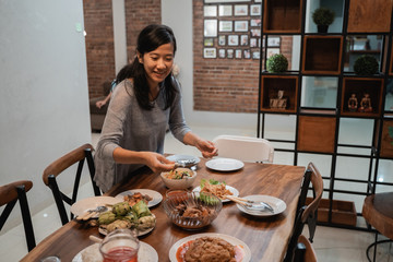 young house wife preparing table for dinner in the evening