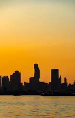 Fototapeta na wymiar Silhouette of city inside the river at sunset