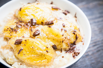 Oatmeal with roasted bananas and chocolate. Selective focus. Shallow depth of field.