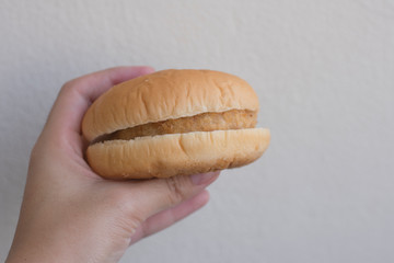 Hand holding tasteless burger