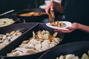 Dumplings with meat, onions on a big cast iron skillet.
