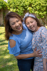 Fototapeta premium Latina Mother and Daughter Smiling and laughing outside in back yard