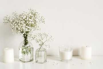 White arrangement of baby's breath flowers and candles. Copy space for lettering