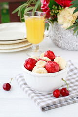 Glass of banana juice and fruit salad on the table.