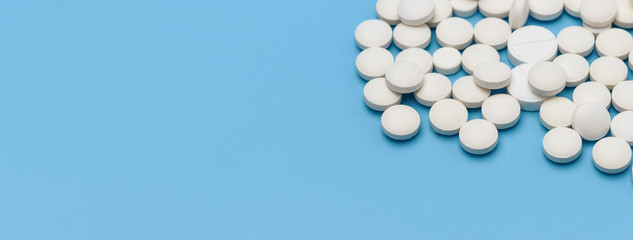 Banner. A lot of white round tablets on the right on a blue background, on the left an empty space for an advertising signature