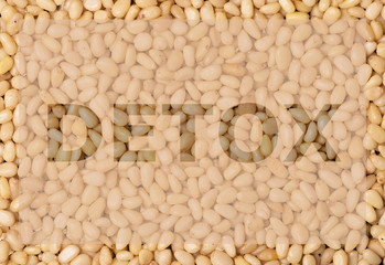 the word detox on a background of speckled nuts