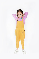 Little Asian child girl wearing a yellow dungarees isolated on white background.