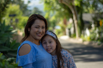 Naklejka premium Latina Mother and Daughter Smiling and laughing on suburban street
