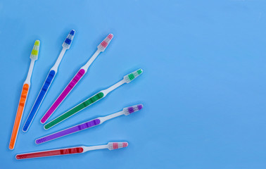 Obraz premium A lot of toothbrushes lie on a pastel blue background with copy space. Top view, flat lay. Minimal concept