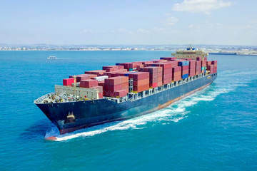 Aerial image of a Container ship at sea, loaded with various container brands.