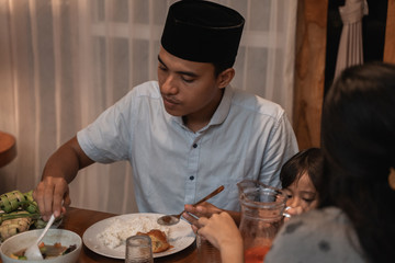 Fototapeta na wymiar handsome asian young muslim man eating dinner with family