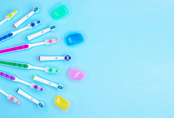 Multi-colored toothbrushes on a blue background with copy space. Flat lay. Top view.