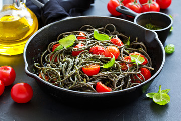 Spaghetti with cuttlefish ink and tomatoes.