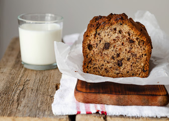 Banana cake on a wooden background with a glass of milk