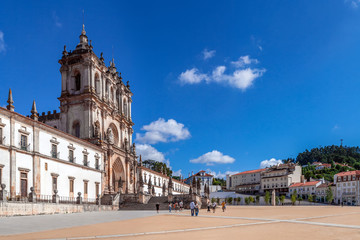 Fototapeta na wymiar Alcobaca, Portugal. Exterior facade of Monastery of Santa Maria de Alcobaca Abbey. Masterpiece of Medieval Gothic architecture. Cistercian Religious Order