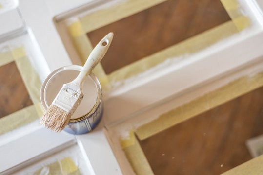 top view of paint brush on white color can. wooden door painting.