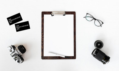 blank notebook with computer, smart phone, coffee and vintage camera on white wood background, business concept