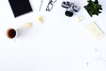 Creative flat lay photo of plain white desk with old camera, note book, pen glasses, sticky, Top view with copy space