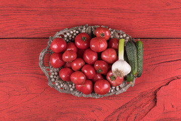 red tomatoes on a vintage tray on a red wooden table
