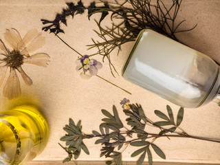 Styled beauty background, web banner. Skin mask, tonicum bottle, dry flowers, leaves. Organic cosmetics, spa concept. top view