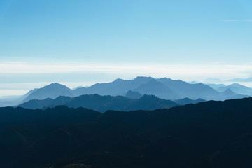 Scenic view of silhouettes of mountains in the morning mist