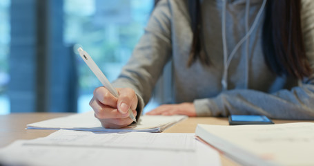 Woman study the note on paper at library