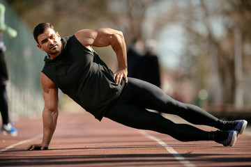 Athlete warming up. Man doing plank. Guy warming up before a workout. 