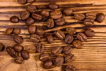 Scattered coffee beans on a wooden table. Top view