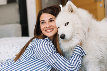 Cute girl petting her dog. Beautiful girl having fun with her dog and enjoying herself. Girl and her dog at home