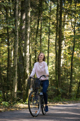 Obraz premium Happy young woman riding a bike