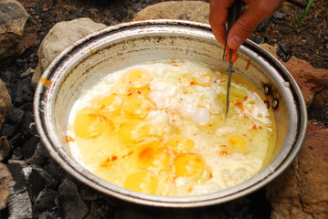cooking omelet over campfire in the morning