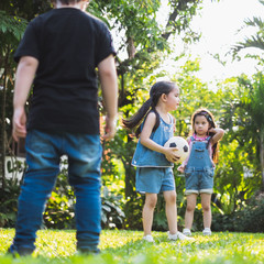 Group of kids playing football at playground outdoor