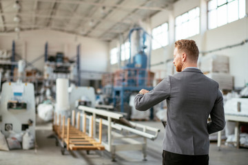 Fototapeta premium Factory supervisor on duty. Inspector comes to a factory Manager at a factory. Boss checking the warehouse during the day