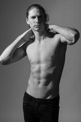 Fototapeta premium Black and white photo of a topless man. Gray background