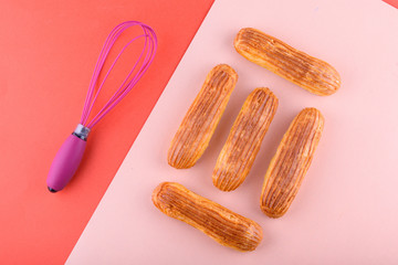 Tasty and beautiful eclairs on a colored background. Delicious dessert